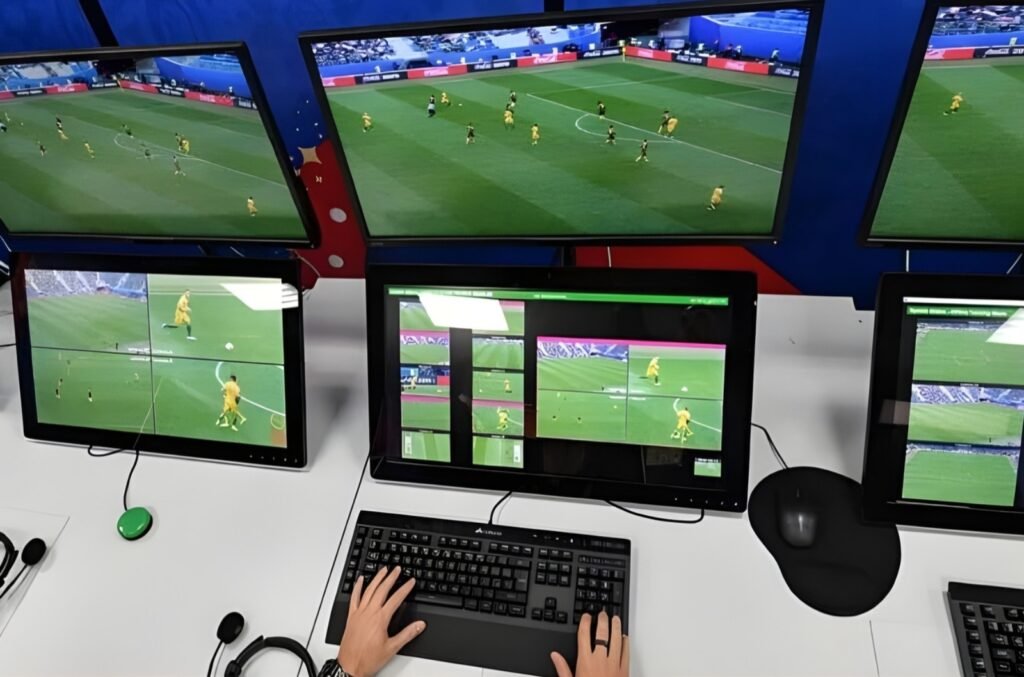 VAR officials analyzing multiple live camera angles on screens during a Champions League match review inside the UEFA VAR control room